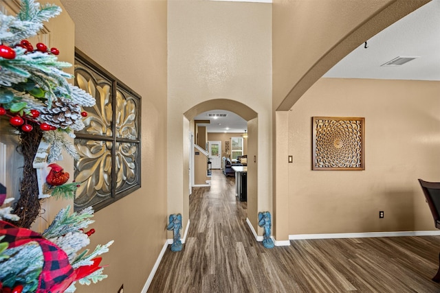 corridor featuring dark hardwood / wood-style floors and a high ceiling