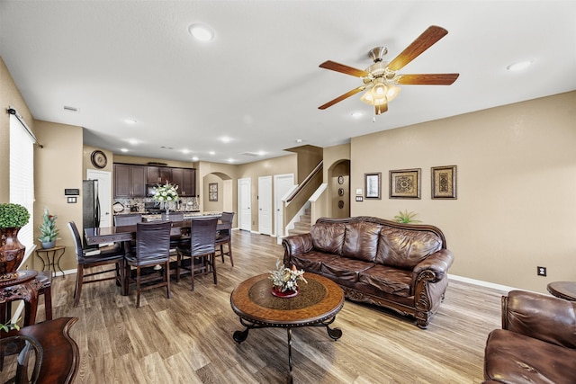 living room with ceiling fan and light wood-type flooring