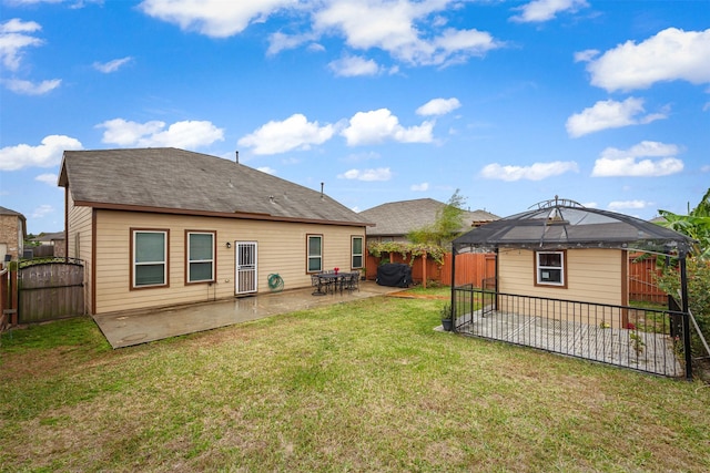 rear view of house with a gazebo, a patio, and a yard