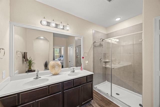 bathroom featuring a shower with door, vanity, and wood-type flooring