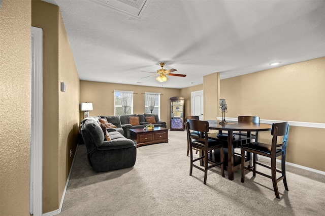 carpeted dining space with ceiling fan and a textured ceiling