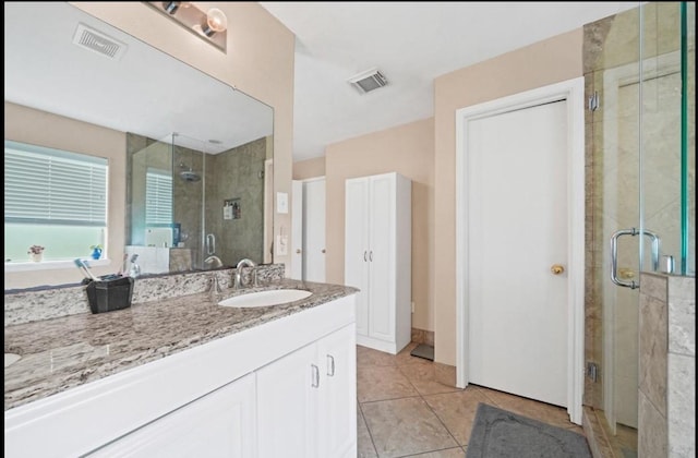 bathroom featuring tile patterned floors, vanity, and a shower with shower door