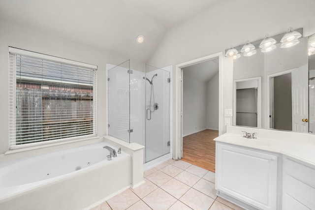 bathroom with tile patterned flooring, vanity, separate shower and tub, and vaulted ceiling