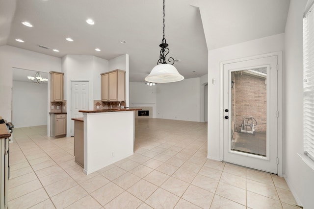 kitchen with backsplash, light brown cabinets, light tile patterned floors, and decorative light fixtures