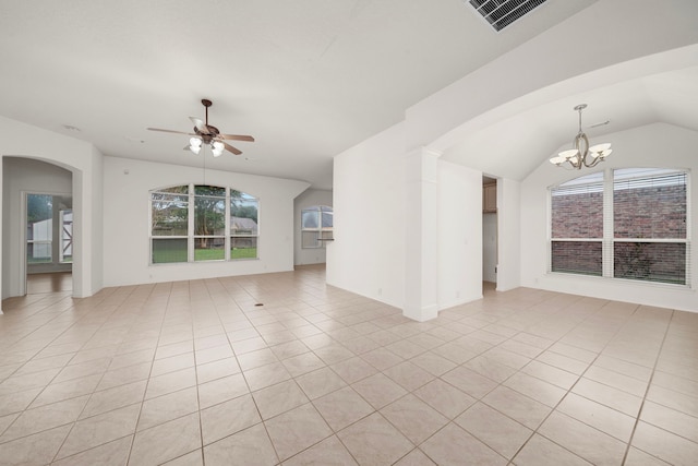 empty room featuring ceiling fan with notable chandelier, light tile patterned flooring, and a wealth of natural light