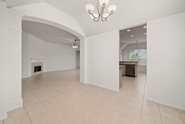 unfurnished room with a fireplace, light tile patterned floors, ceiling fan with notable chandelier, and lofted ceiling