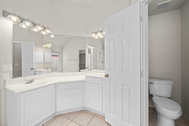 bathroom with tile patterned flooring, vanity, toilet, and lofted ceiling