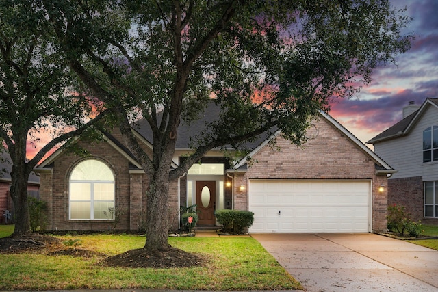 view of front of property featuring a lawn and a garage