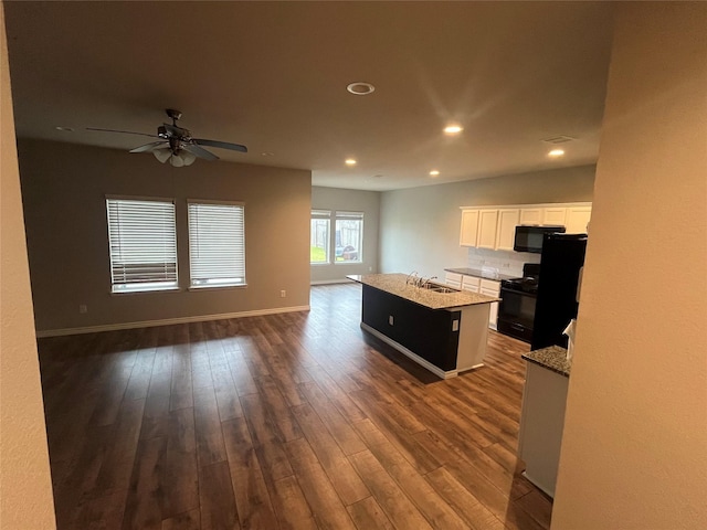 kitchen with a center island with sink, dark hardwood / wood-style flooring, white cabinets, and black appliances