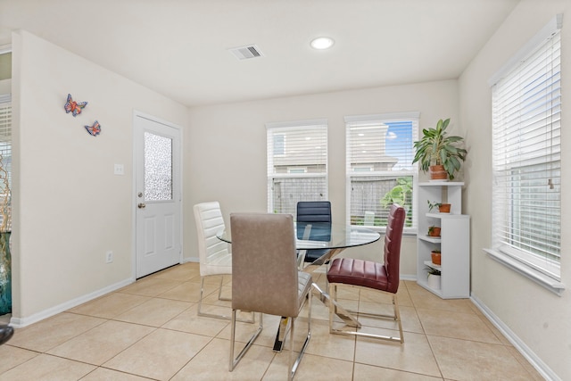 tiled dining space featuring a healthy amount of sunlight