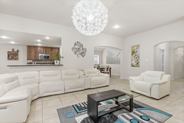 tiled living room with a notable chandelier