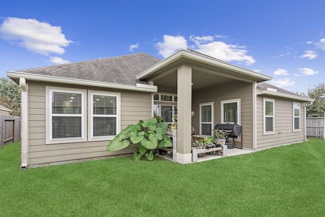 back of property with a patio area and a lawn