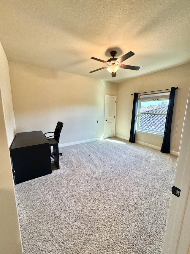 unfurnished office with light carpet, ceiling fan, and a textured ceiling