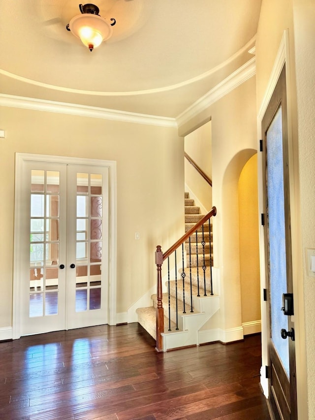 foyer featuring french doors, dark hardwood / wood-style floors, and crown molding