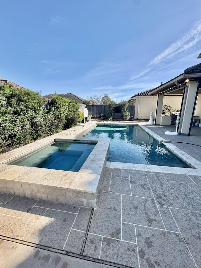 view of pool with an in ground hot tub, a patio area, a fenced backyard, and a fenced in pool