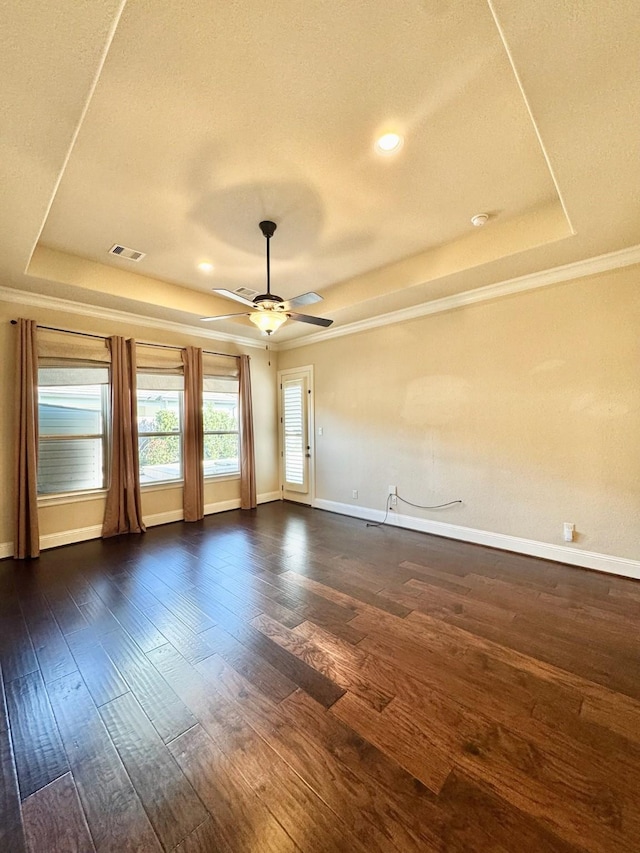 unfurnished room with ceiling fan, dark hardwood / wood-style flooring, and a tray ceiling