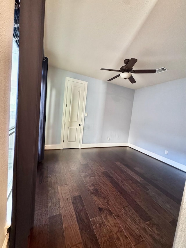 spare room with ceiling fan, dark wood-type flooring, and a wealth of natural light