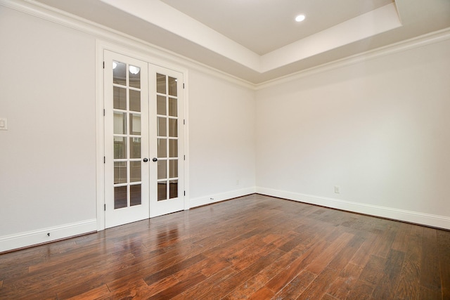 spare room with baseboards, a tray ceiling, wood finished floors, and french doors