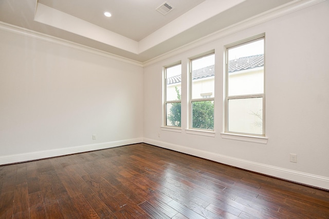 unfurnished room with dark wood-style floors, visible vents, and a raised ceiling