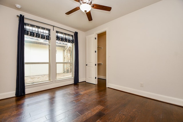 unfurnished room featuring ceiling fan, baseboards, and dark wood finished floors