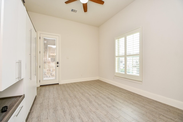 spare room with light wood-type flooring, baseboards, and visible vents