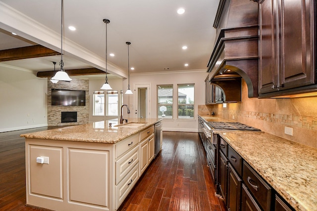 kitchen with tasteful backsplash, dark brown cabinetry, a sink, an island with sink, and light stone countertops