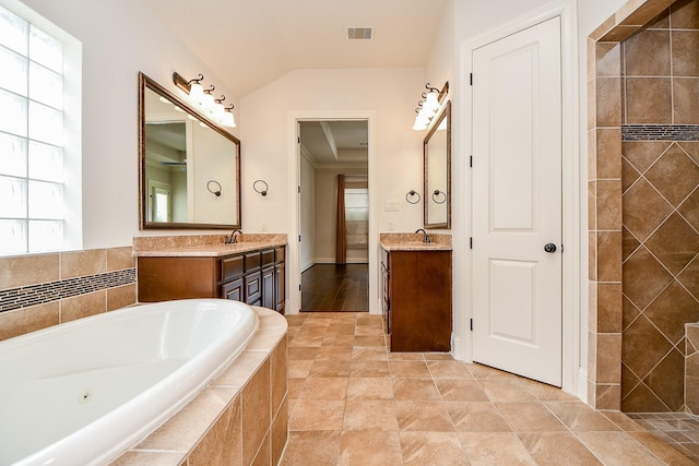 full bath featuring two vanities, visible vents, a sink, and a bath