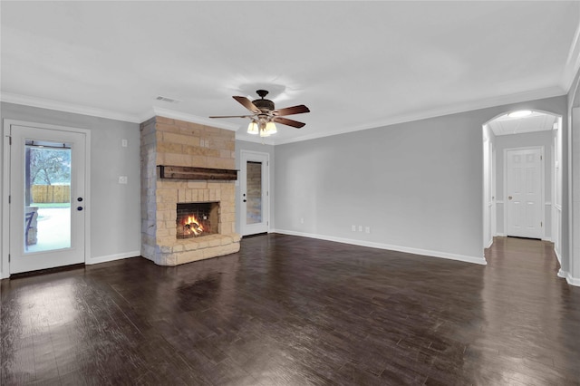 unfurnished living room featuring dark hardwood / wood-style floors, ceiling fan, a stone fireplace, and ornamental molding