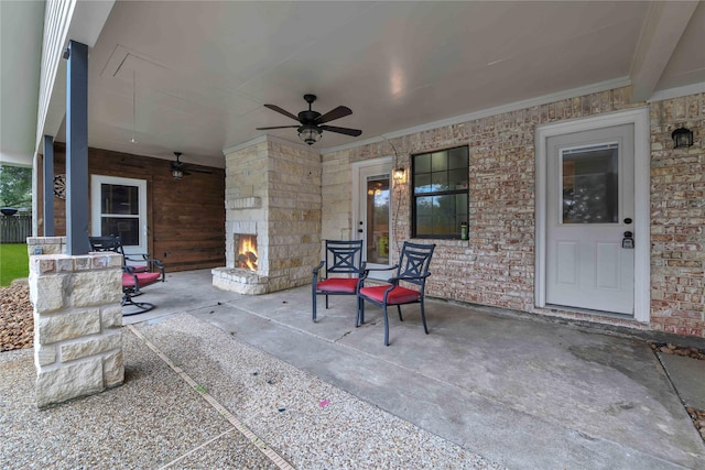 view of patio featuring covered porch, an outdoor stone fireplace, and ceiling fan