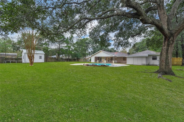 view of yard with a storage unit and a fenced in pool