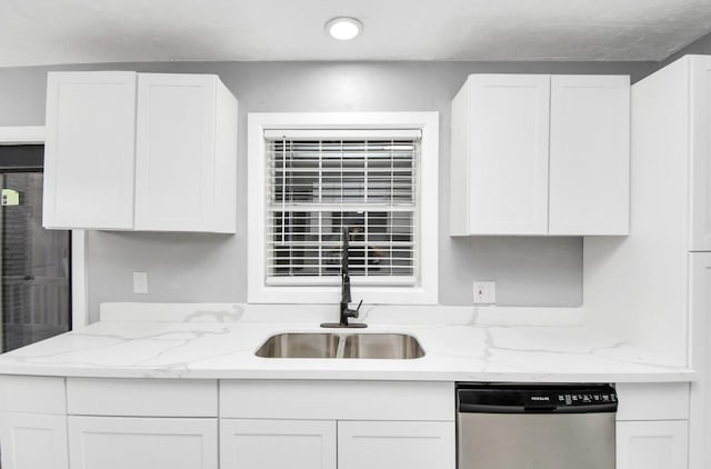 kitchen featuring light stone counters, dishwasher, and white cabinets