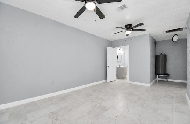 unfurnished bedroom with ceiling fan and connected bathroom