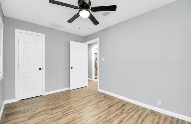 unfurnished bedroom with ceiling fan, light hardwood / wood-style floors, stainless steel refrigerator, and a closet