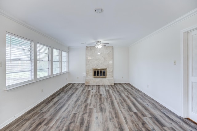 unfurnished living room with a fireplace, ceiling fan, wood-type flooring, and crown molding