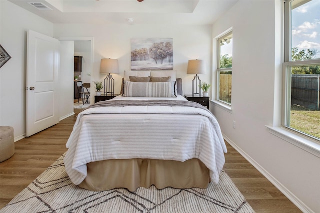 bedroom featuring wood-type flooring and multiple windows