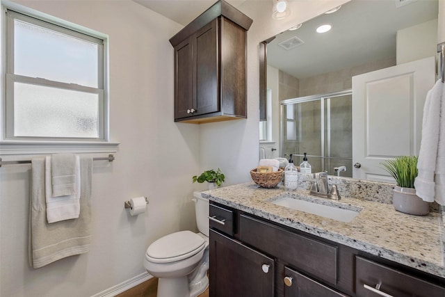 bathroom featuring toilet, an enclosed shower, and vanity