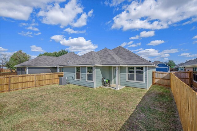 rear view of property featuring a lawn and cooling unit