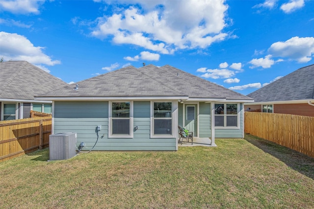 rear view of house with a lawn and central AC