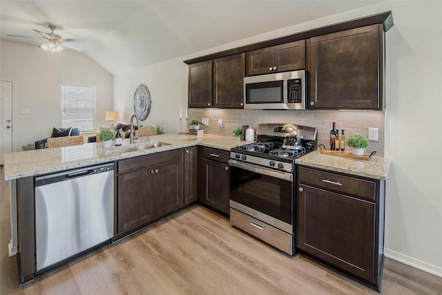 kitchen with light hardwood / wood-style floors, sink, kitchen peninsula, and stainless steel appliances