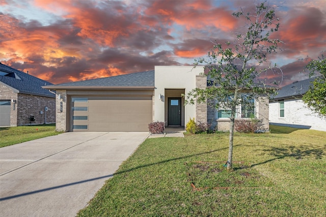 view of front of property featuring a yard and a garage