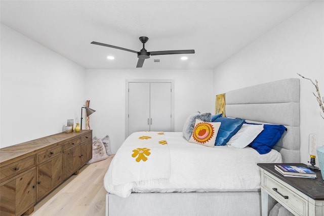 bedroom featuring ceiling fan, light hardwood / wood-style floors, and a closet