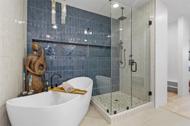 bathroom featuring tile patterned flooring, tile walls, and independent shower and bath