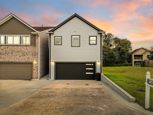 view of front of house featuring a garage and a lawn