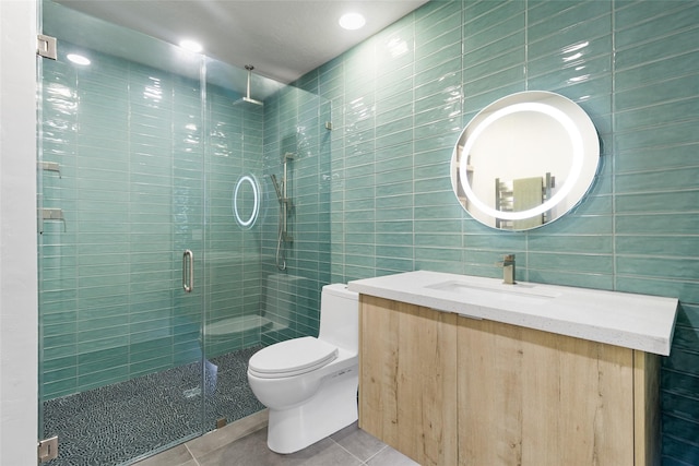 bathroom featuring walk in shower, vanity, tile walls, toilet, and tile patterned floors