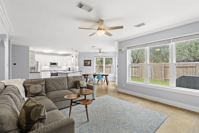 tiled living room featuring ceiling fan and sink