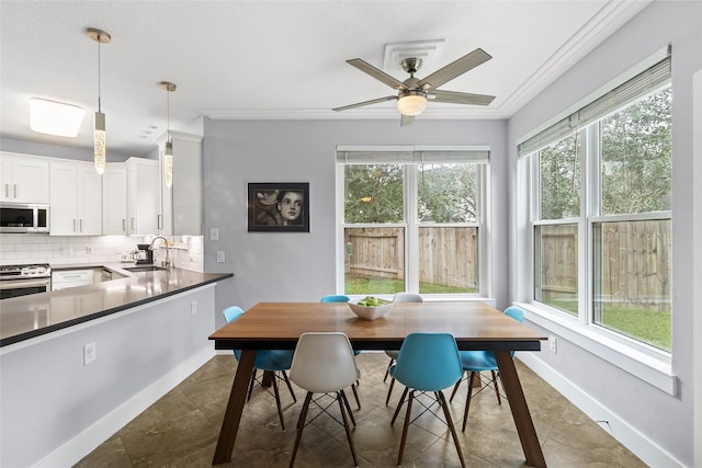 tiled dining area featuring ceiling fan, sink, and ornamental molding