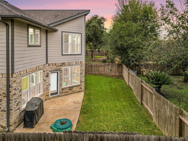 yard at dusk with a patio area