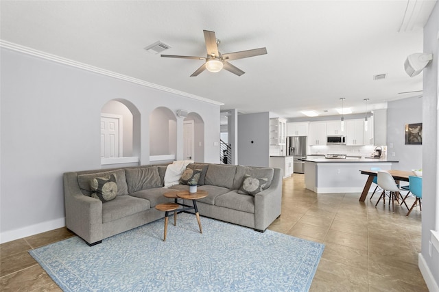 living room featuring light tile patterned floors, ceiling fan, ornamental molding, and sink