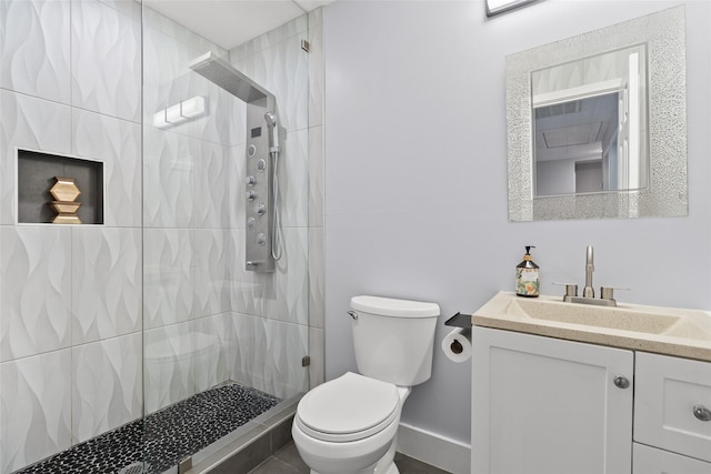 bathroom with toilet, vanity, and a tile shower