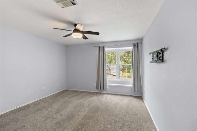 carpeted empty room featuring ceiling fan and a textured ceiling